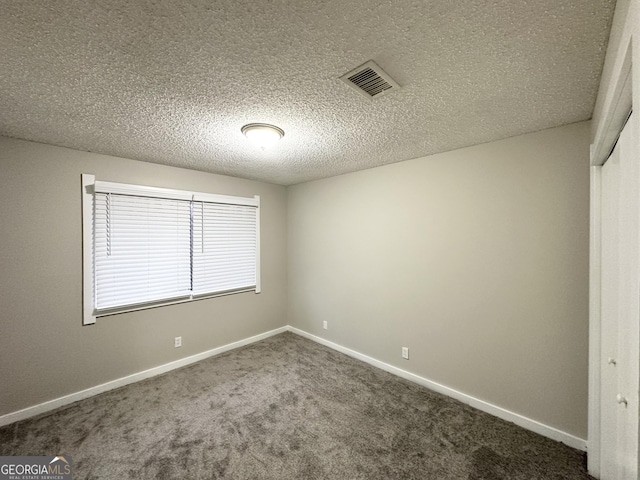 unfurnished room with carpet floors and a textured ceiling