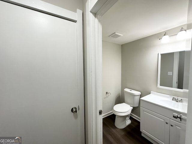 bathroom featuring vanity, toilet, and hardwood / wood-style floors