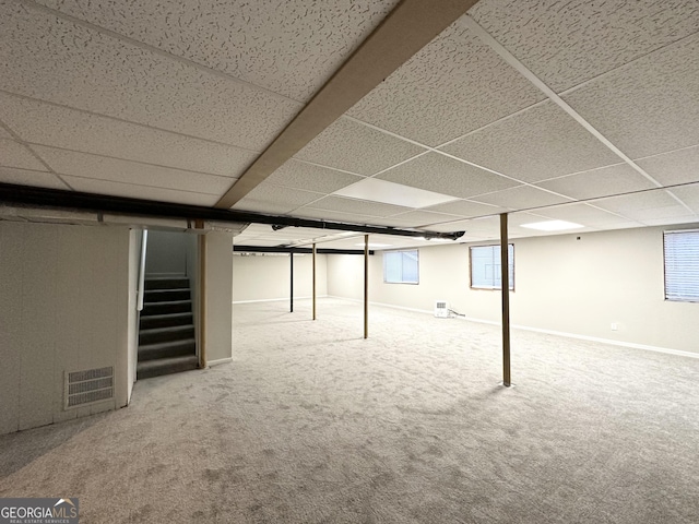 basement featuring carpet floors and a paneled ceiling