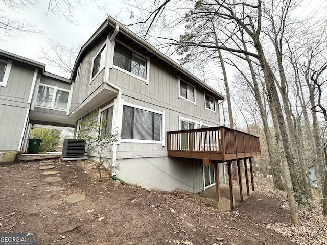 rear view of house with a wooden deck and central AC unit