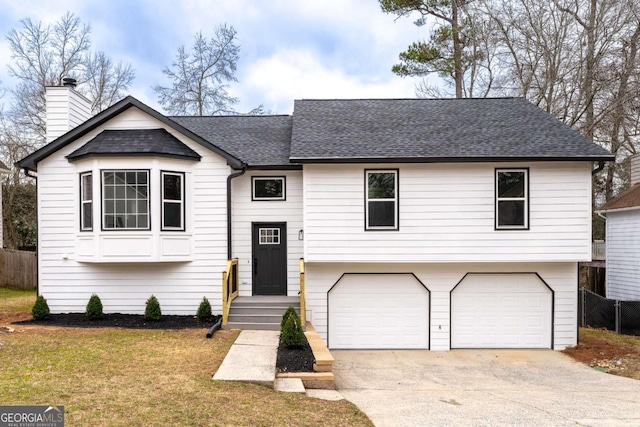 bi-level home featuring a garage and a front yard