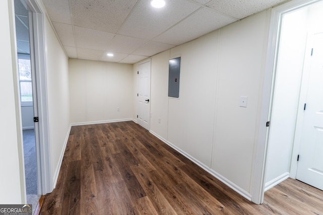 interior space featuring electric panel, dark hardwood / wood-style flooring, and a paneled ceiling