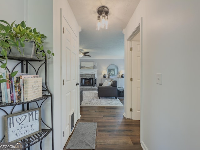 hallway with dark hardwood / wood-style flooring and a textured ceiling