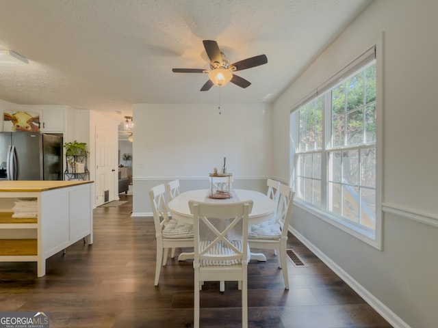 dining space with a textured ceiling, ceiling fan, and dark hardwood / wood-style floors