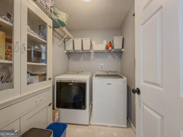 washroom featuring washing machine and dryer and a textured ceiling