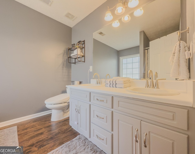 bathroom with hardwood / wood-style floors, vanity, and toilet