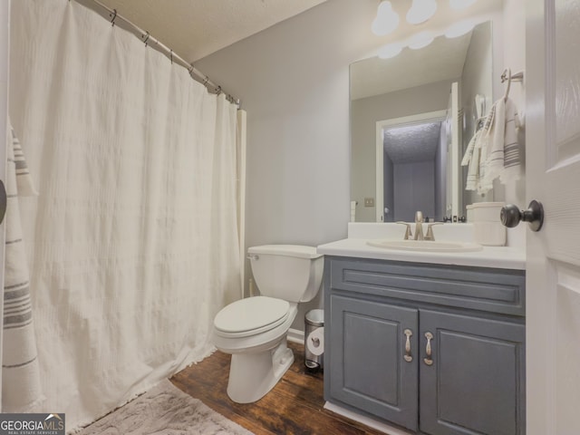 bathroom with wood-type flooring, vanity, and toilet