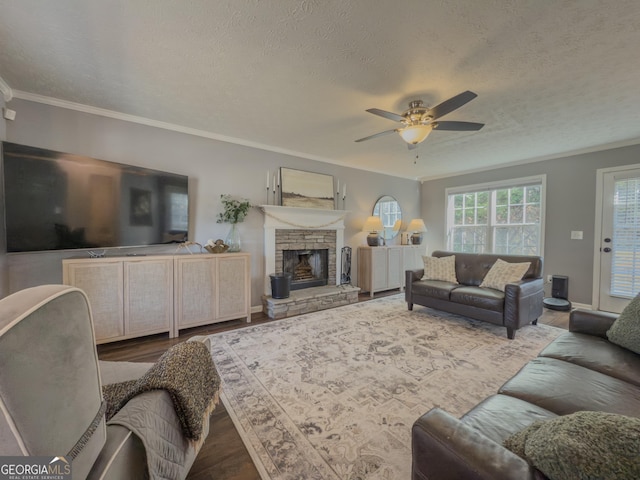 living room featuring a textured ceiling, ornamental molding, ceiling fan, and wood-type flooring