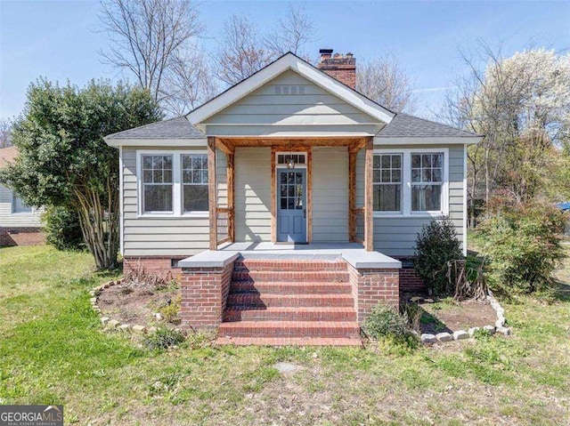 bungalow featuring a porch and a front lawn