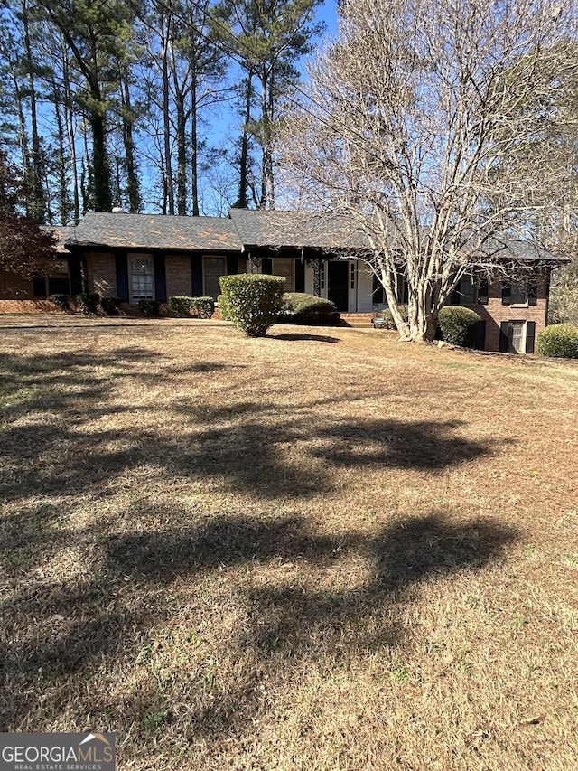 ranch-style home with central AC and a front lawn