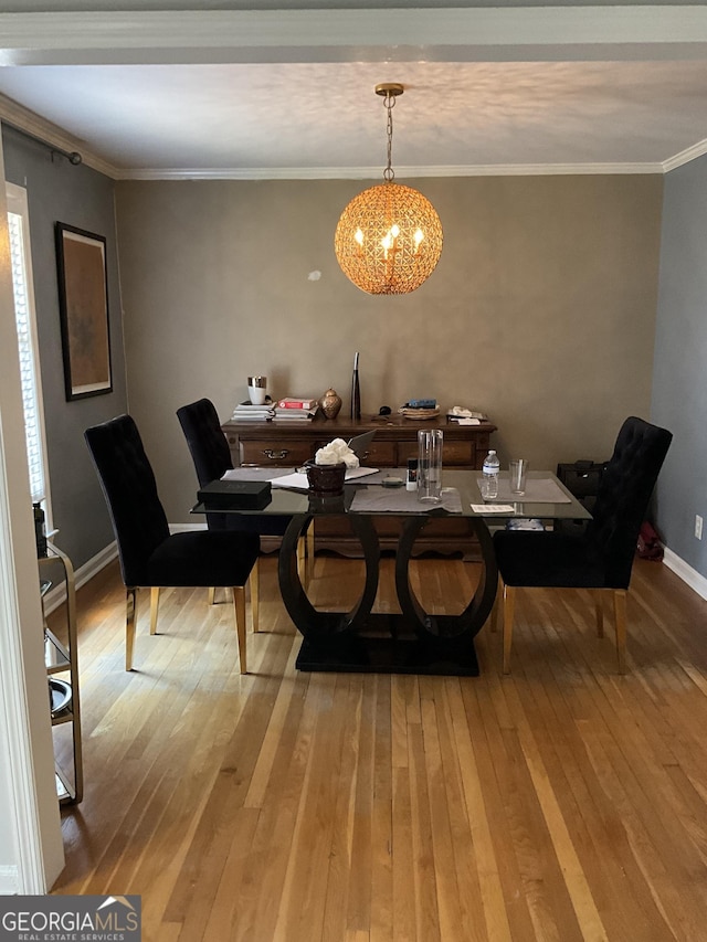 dining room with crown molding, hardwood / wood-style floors, and a chandelier