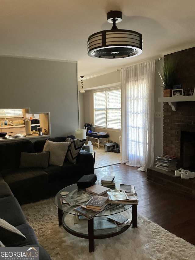 living room featuring wood-type flooring and a brick fireplace