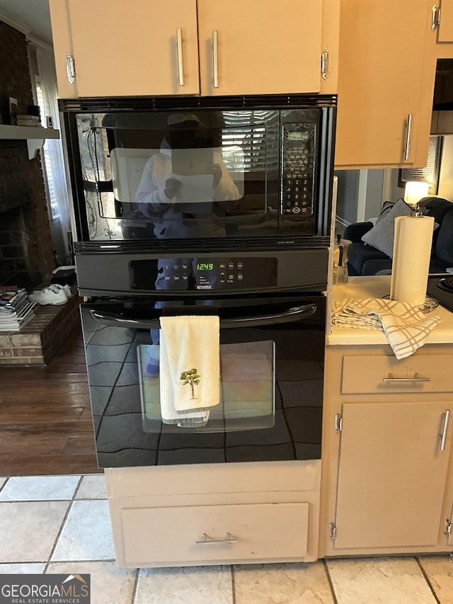 kitchen featuring a fireplace and black appliances