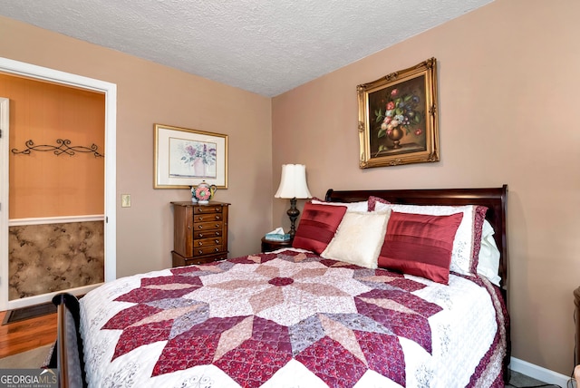 bedroom featuring hardwood / wood-style flooring and a textured ceiling