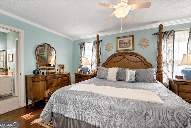 bedroom with ornamental molding, wood-type flooring, ensuite bathroom, and a textured ceiling