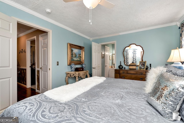 bedroom featuring ensuite bath, ceiling fan, crown molding, dark wood-type flooring, and a textured ceiling