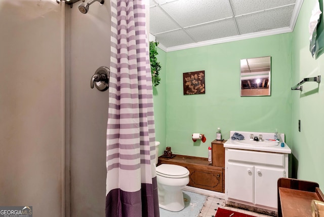 bathroom with a drop ceiling, vanity, curtained shower, and toilet