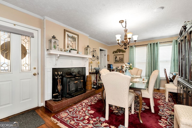 dining room featuring an inviting chandelier, ornamental molding, dark hardwood / wood-style floors, and a textured ceiling