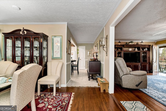 living room featuring hardwood / wood-style flooring, ornamental molding, and a textured ceiling