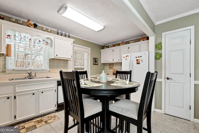 dining room with crown molding, sink, and a textured ceiling