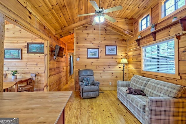 living room with lofted ceiling, wood ceiling, light hardwood / wood-style flooring, and wood walls