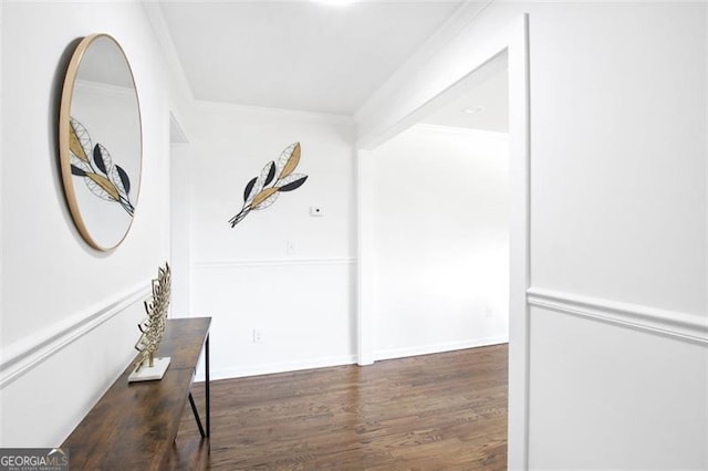 hall featuring ornamental molding, dark wood-style flooring, and baseboards