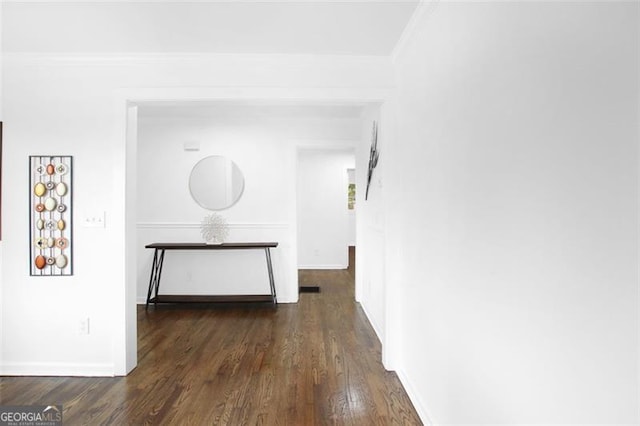 hallway featuring ornamental molding, dark wood finished floors, and baseboards