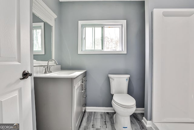 bathroom with vanity, toilet, and hardwood / wood-style floors