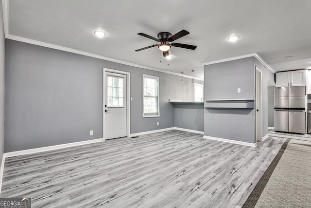 kitchen featuring light hardwood / wood-style flooring, stainless steel fridge, ornamental molding, white cabinetry, and kitchen peninsula