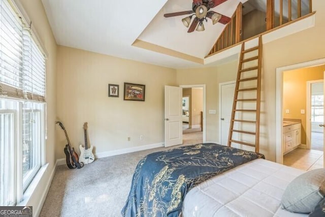 bedroom featuring high vaulted ceiling, connected bathroom, and light colored carpet