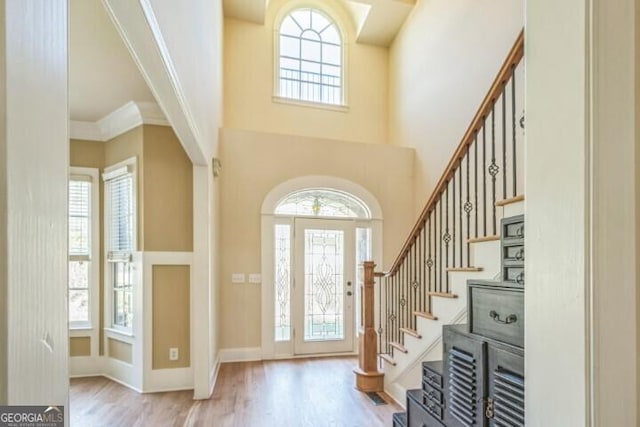 foyer entrance featuring ornamental molding, light hardwood / wood-style flooring, and plenty of natural light