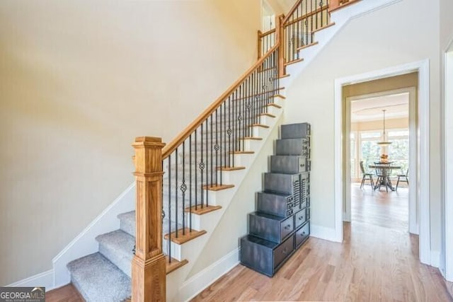 stairway featuring hardwood / wood-style floors and a towering ceiling