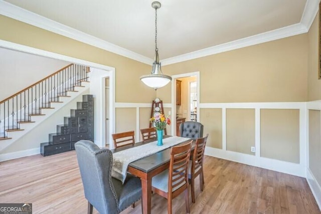 dining area featuring wood-type flooring and ornamental molding