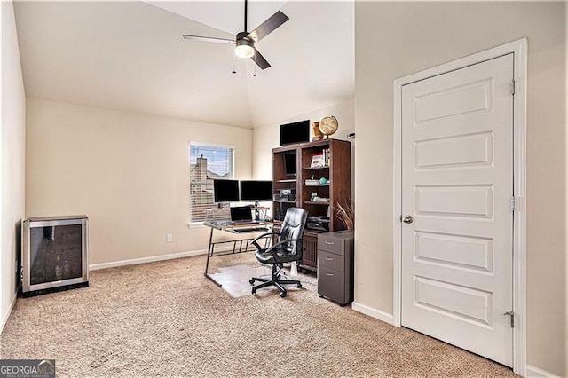 home office featuring vaulted ceiling, light carpet, and ceiling fan