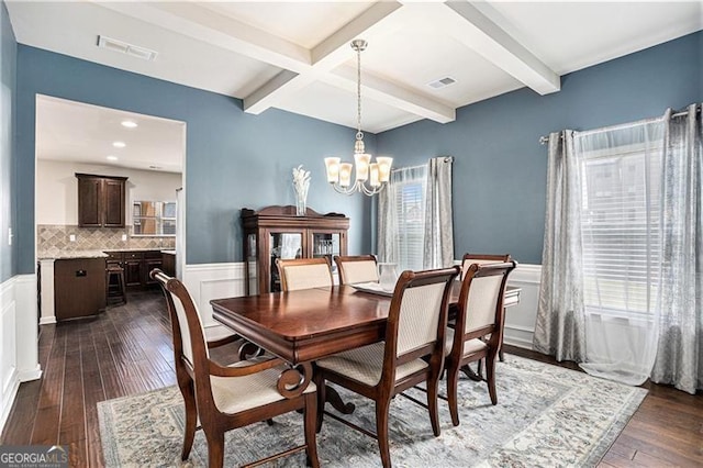 dining space with an inviting chandelier, dark hardwood / wood-style floors, coffered ceiling, and beam ceiling