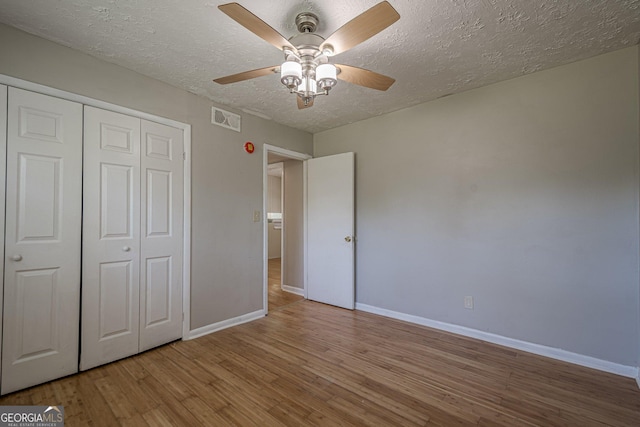 3710 Lynn Dr, Powder Springs, GA 30127 - unfurnished bedroom with baseboards, wood finished floors, visible vents, and a textured ceiling