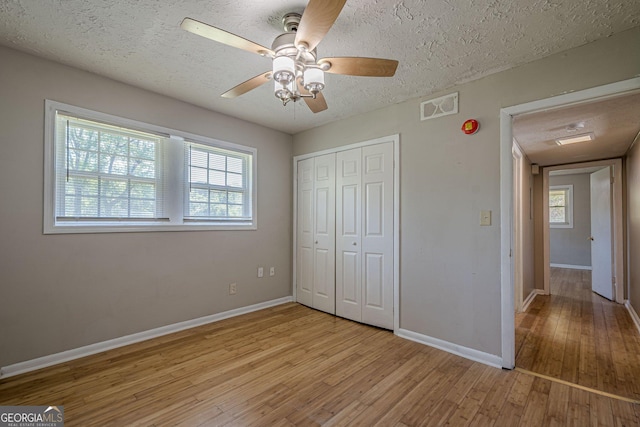3710 Lynn Dr, Powder Springs, GA 30127 - unfurnished bedroom featuring visible vents, light wood-type flooring, a closet, a textured ceiling, and multiple windows