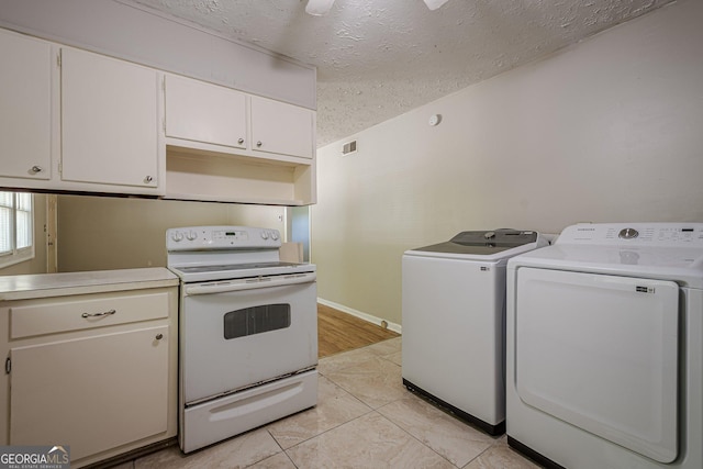 3710 Lynn Dr, Powder Springs, GA 30127 - kitchen featuring white cabinets, a textured ceiling, electric range, light countertops, and washer and dryer