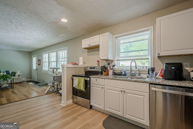 3710 Lynn Dr, Powder Springs, GA 30127 - kitchen featuring light wood-type flooring, a textured ceiling, stainless steel appliances, and a sink