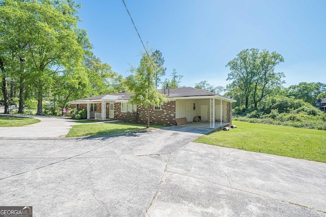 3710 Lynn Dr, Powder Springs, GA 30127 - ranch-style home featuring concrete driveway, brick siding, a carport, and a front yard