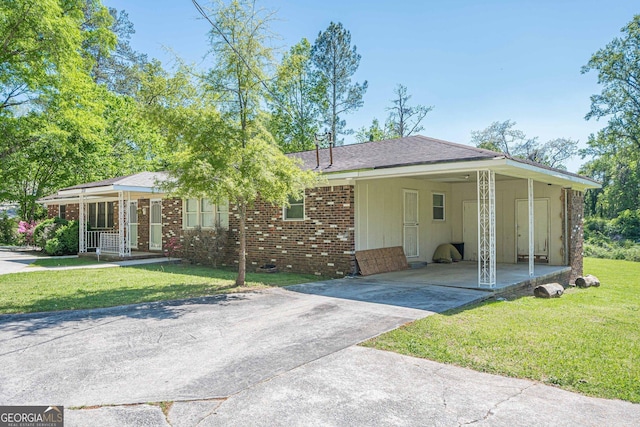3710 Lynn Dr, Powder Springs, GA 30127 - view of front of property with concrete driveway, a front lawn, covered porch, an attached carport, and brick siding