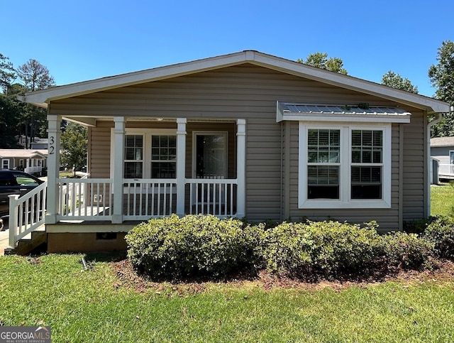 view of front of house featuring covered porch and a front yard