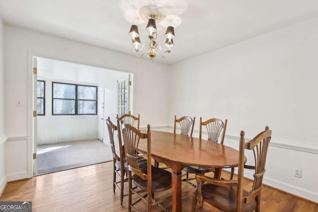 dining area featuring wood-type flooring and a chandelier