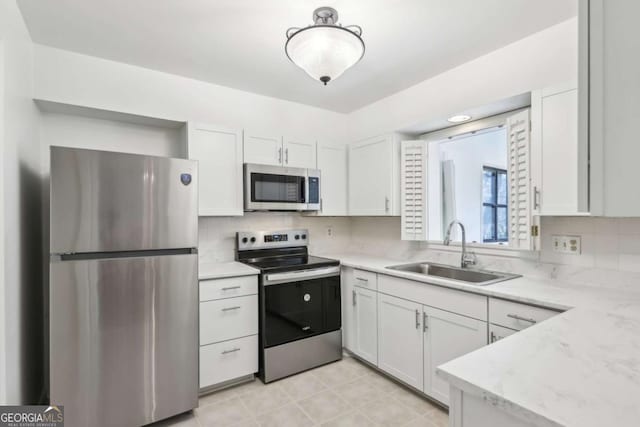 kitchen featuring white cabinetry, sink, decorative backsplash, and stainless steel appliances