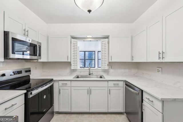 kitchen featuring white cabinetry, sink, backsplash, and appliances with stainless steel finishes