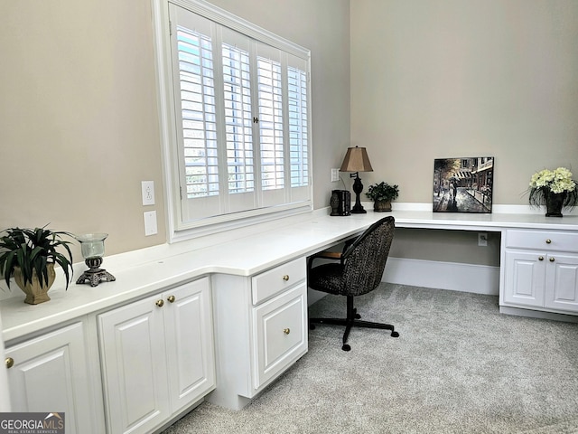 carpeted home office featuring built in desk