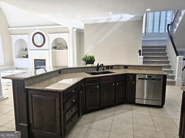 kitchen with a kitchen island with sink, sink, light stone counters, and stainless steel dishwasher