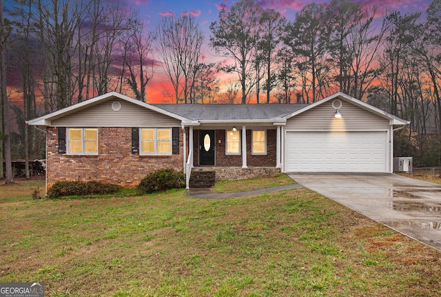 ranch-style home with a yard and a garage