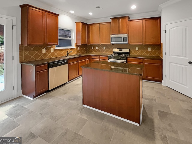 kitchen with a kitchen island, sink, backsplash, stainless steel appliances, and crown molding