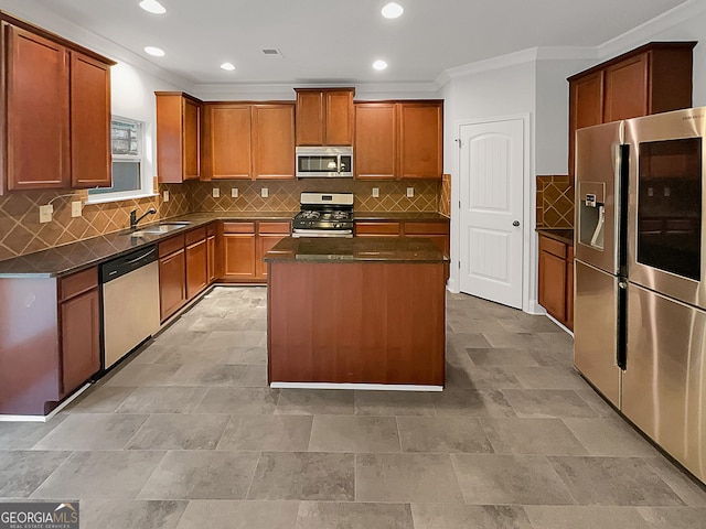 kitchen featuring sink, crown molding, appliances with stainless steel finishes, a center island, and decorative backsplash